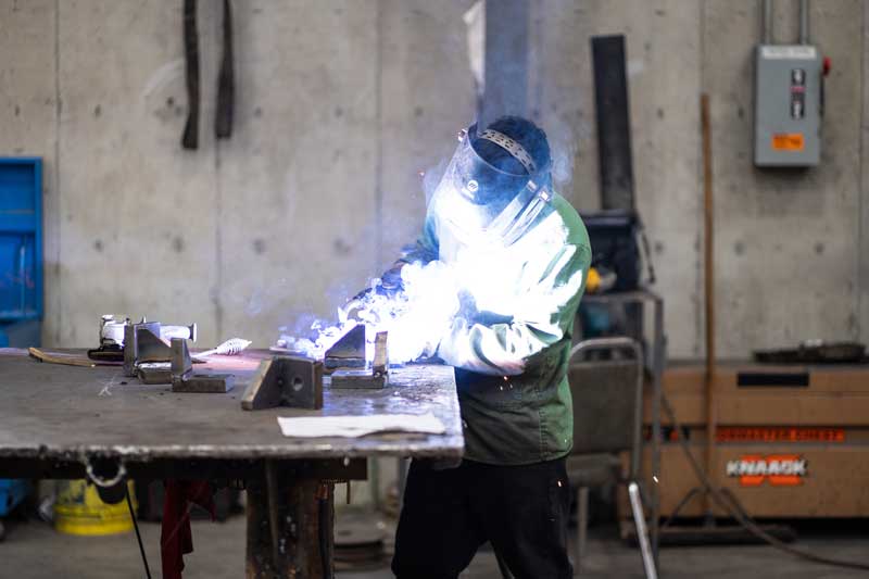 H&H employee welding metal